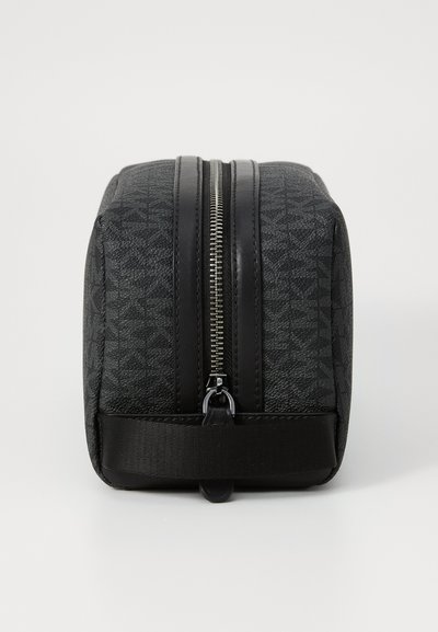 Trousse de toilette noire zippée avec un motif géométrique texturé, matériau synthétique mat et une base plate pour la stabilité.