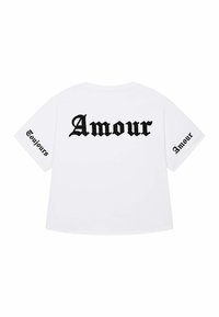 Witte oversized t-shirt met grote zwarte gotische tekst, "Amour," op de achterkant en "Toujours" op de rechtermouw. Zachte stof, casual snit.