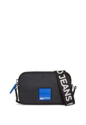 Černá kožená crossbody taška s modrým čtvercovým akcentem a logem, zipovým uzávěrem a nastavitelným pruhovaným popruhem s nápisem "KARL LAGERFELD JEANS."