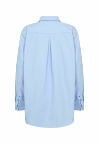 Gaiši zils krekls ar garām piedurknēm, aizmugurējo yoke un centrālu krokas, aizpogājamām aprocēm un klasisku apkakli.