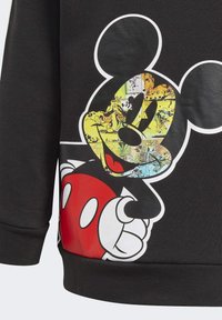 Sweatshirt nero con un design di Topolino stampato. Il grafico include elementi colorati in stile fumetto con accenti gialli e blu.