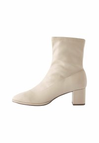 Beige ankle boot made of smooth leather, featuring a pointed toe and a square heel. Seamless design with minimal stitching detail.