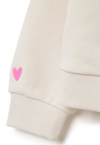Crème-kleurige sweatshirt met ribgebreide manchetten en een kleine roze hartje geborduurd op de mouw. Zachte, gestructureerde stof.