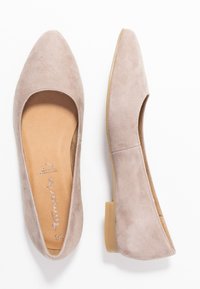 Bailarinas de ante beige con puntera afilada y tacón bajo y transparente. Forro interior suave con detalle del logo en la plantilla. Diseño minimalista.