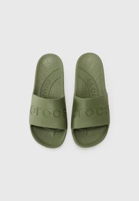 Infradito in gomma verde con una superficie testurizzata, fasce larghe con il logo "crocs" in rilievo e piccoli fori di ventilazione per una maggiore traspirabilità.