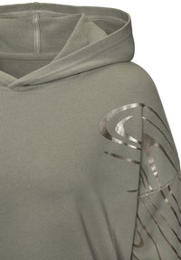Olivengrüner Kapuzenpullover mit einem großen metallisch silbernen Wirbel-Design, der eine weiche Textur und eine Kordelzugkapuze aufweist. Nähte sorgen für Struktur.
