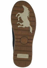 Semelle de chaussure en caoutchouc brun avec un logo de cheval cabré, des lignes de grip texturées et un emblème circulaire en étoile. Nom de la marque "MUSTANG" en relief sur la semelle.