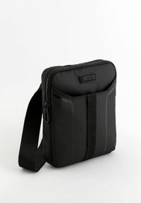 Svart nylon axelväska med rektangulär form, som har en övre dragkedja, framstående remaccent och minimalistiska designelement.