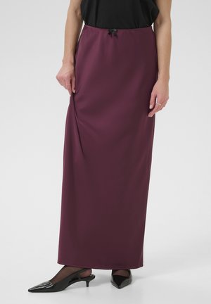 Bordeaux maxi rok van soepele stof, met een koordtaille en zijzakken. Gepaard met zwarte puntige hakken.