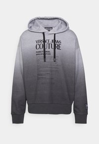 Šedá mikina s přechodem odstínu, s velkým potištěným logem a textem na přední straně, šňůrkami u kapuce a žebrovanými manžetami na rukávech.