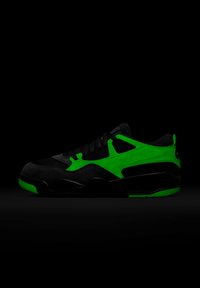 Czarno-zielony niski but sportowy z czarnymi sznurowadłami, wykonany z siateczki i zamszu, z grubą podeszwą na ciemnym tle.