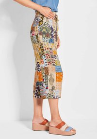 Gecombineerde cropped broek met een mix van kleurrijke bloemen- en geometrische patronen, voorzien van een elastische tailleband en een trekkoord. 
