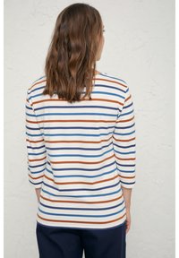 Gestreepte lange mouwen top in het wit, met horizontale blauwe, bruine en oranje strepen. Zachte stof met een ontspannen pasvorm en ronde halslijn.