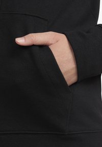 Μαύρη φούτερ μπλούζα με τσέπη μπροστά, μαλακή υφή και ριμπ μανσέτες. Ορατές λεπτομέρειες ραφής και κλασική σχεδίαση.