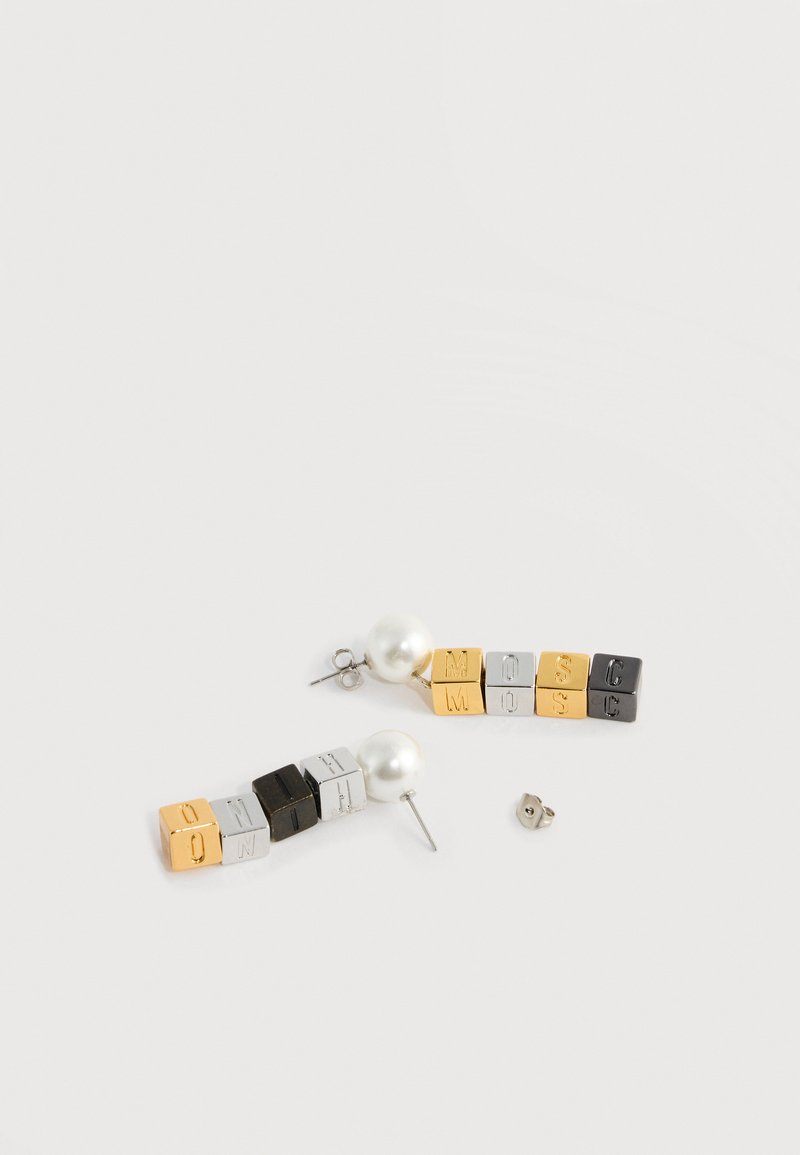 Paire de boucles d'oreilles en forme de cubes colorés formant le mot « MOSCHINO » avec des clous en perle sur fond blanc.