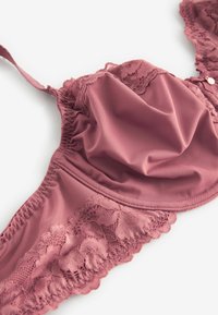 Mauve podprsenka s krajkovými okraji a hladkým materiálem. Obsahuje nastavitelná ramínka a nabrané středové místo, které zvýrazňuje její jemnou texturu a delikátní design.
