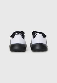 Schwarz-weiße Sportschuhe mit einem Mesh-Obermaterial, rundem Design, schwarzen Gummisohlen und doppelten Ziehlschlaufen für ein einfaches Anziehen.