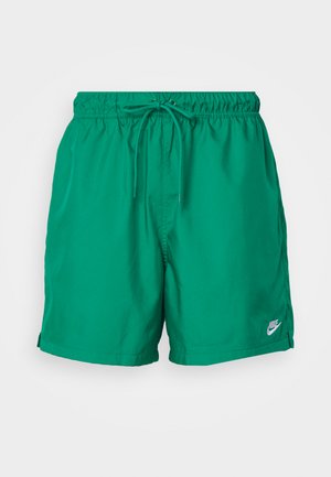 Bañadores verdes para hombre, confeccionados en material ligero, con cintura elástica y cordón ajustable, y un pequeño logo de Nike en el dobladillo.
