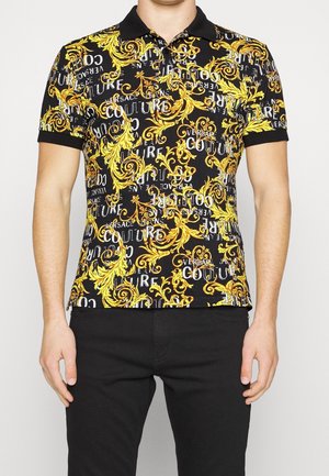 Schwarzes Poloshirt mit einem lebendigen gelben und weißen Barockmuster, über das verteilt Textelemente zu sehen sind, kurze Ärmel und ein schwarzer Kragen.