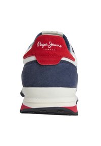 Sapatilha azul-marinho e vermelha com materiais em camurça e malha, apresentando uma sola branca acolchoada e um logo bordado no calcanhar.