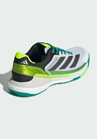 Running shoe with a breathable mesh upper in white, black, and neon green accents, featuring a cushioned sole and textured grip pattern.