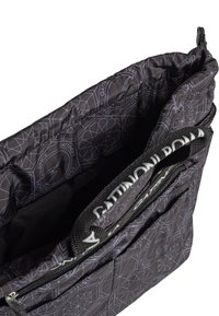 Svart quiltad väska med ett geometriskt mönster, med dragkedjestängning och en texturerad rem. Inuti finns ett rymligt fack och fickor.