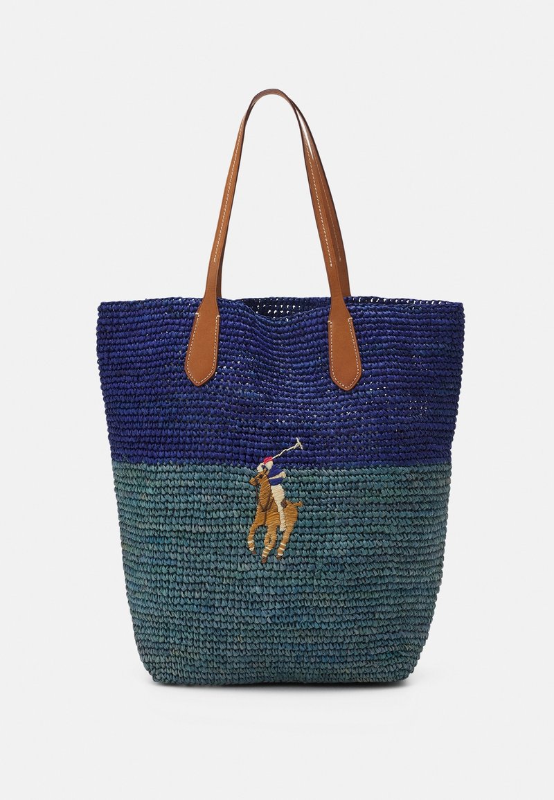 Vävd toteväska i blått och grönt, med bruna läderhandtag och en broderad polo spelare på häst som en anmärkningsvärd detalj.