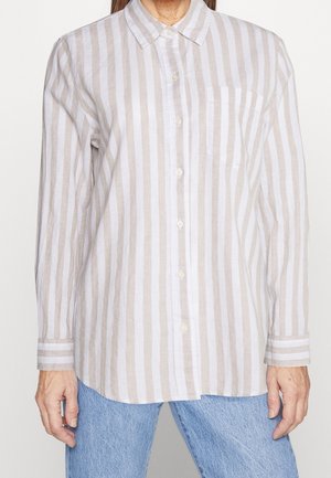 Long-sleeve button-up shirt in light beige and white striped linen. Features a chest pocket and a pointed collar with cuffs. Casual fit.