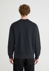 Mörkgrå sweatshirt med långa ärmar, rund hals och ribbade muddar. Slät textur och minimalistisk design, med en avslappnad passform.