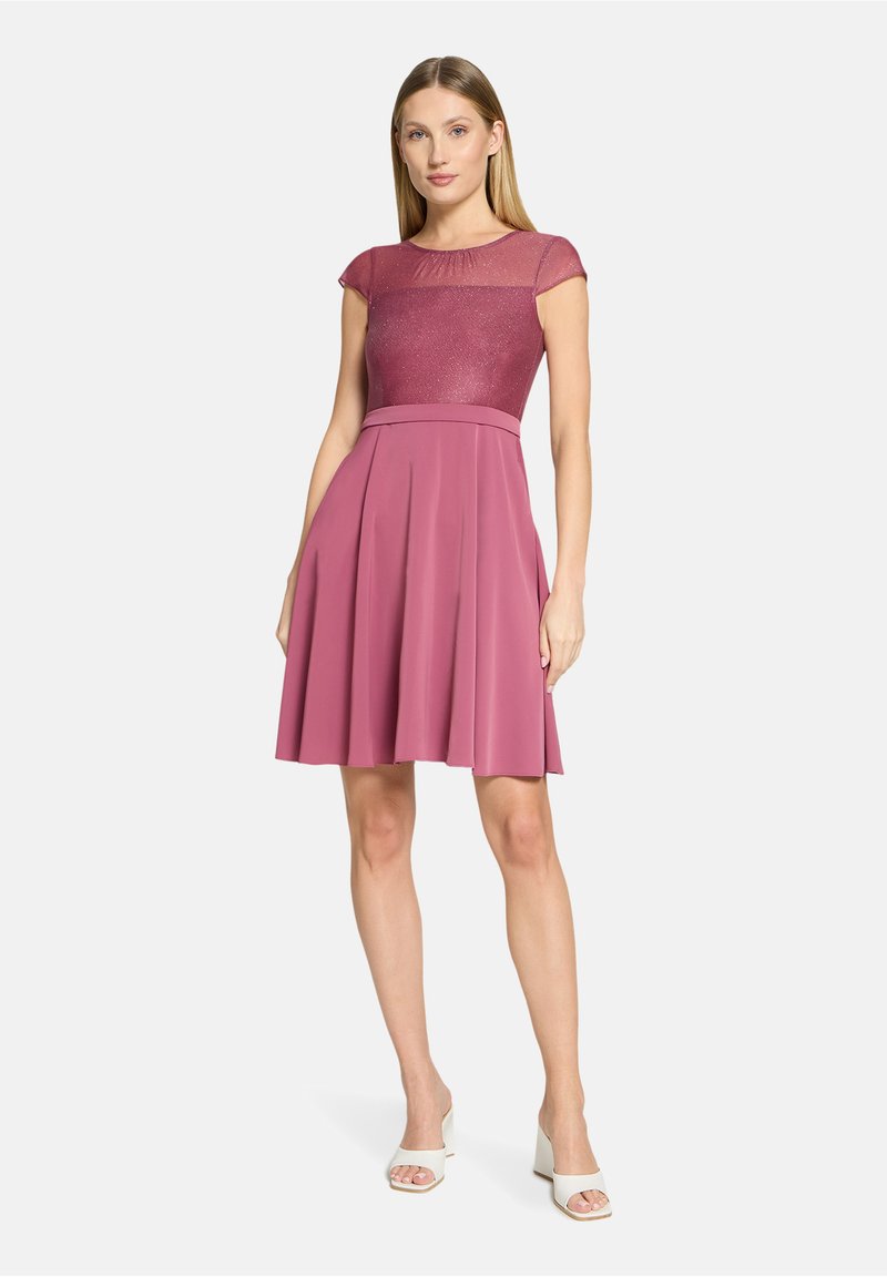Robe à manches courtes avec un corsage ajusté et scintillant et une jupe plissée fluide, toutes deux dans une teinte rose assortie. Tissu lisse et design minimaliste.