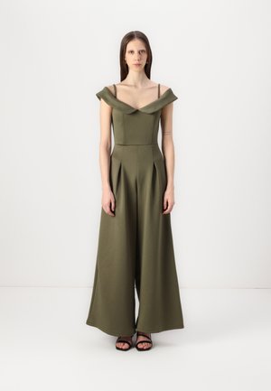 Combinaison vert olive avec design décolleté, jambes larges plissées et bustier ajusté. Fabriquée en tissu lisse et structuré.