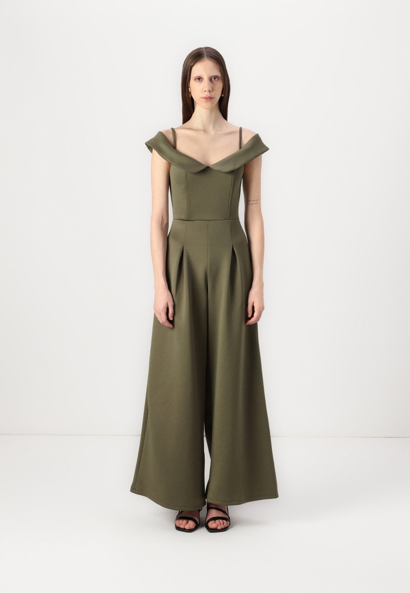 Olivengrønn jumpsuit med avtagbare skulderstropper, plisserte vide ben og en tettsittende overdel. Laget av glatt, strukturert stoff.