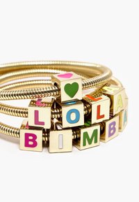Gold-tone bangle bracelet with interlocking metal strands, featuring colorful lettered blocks spelling "LOLA BIMBA" and heart designs.