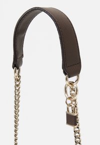 Bracelet en cuir marron avec surface texturée, attaché à une chaîne en or et un fermoir rectangulaire en or, sur fond blanc.