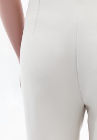 Světlé šedé elastické látkové kalhoty s hladkou texturou, se slim fit siluetou a jemným prošitím po stranách.