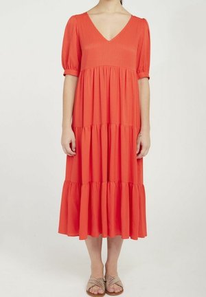 Robe midi rouge avec un décolleté en V, des manches bouffantes courtes et des volants à étages. Fabriquée en tissu texturé avec des rayures verticales.