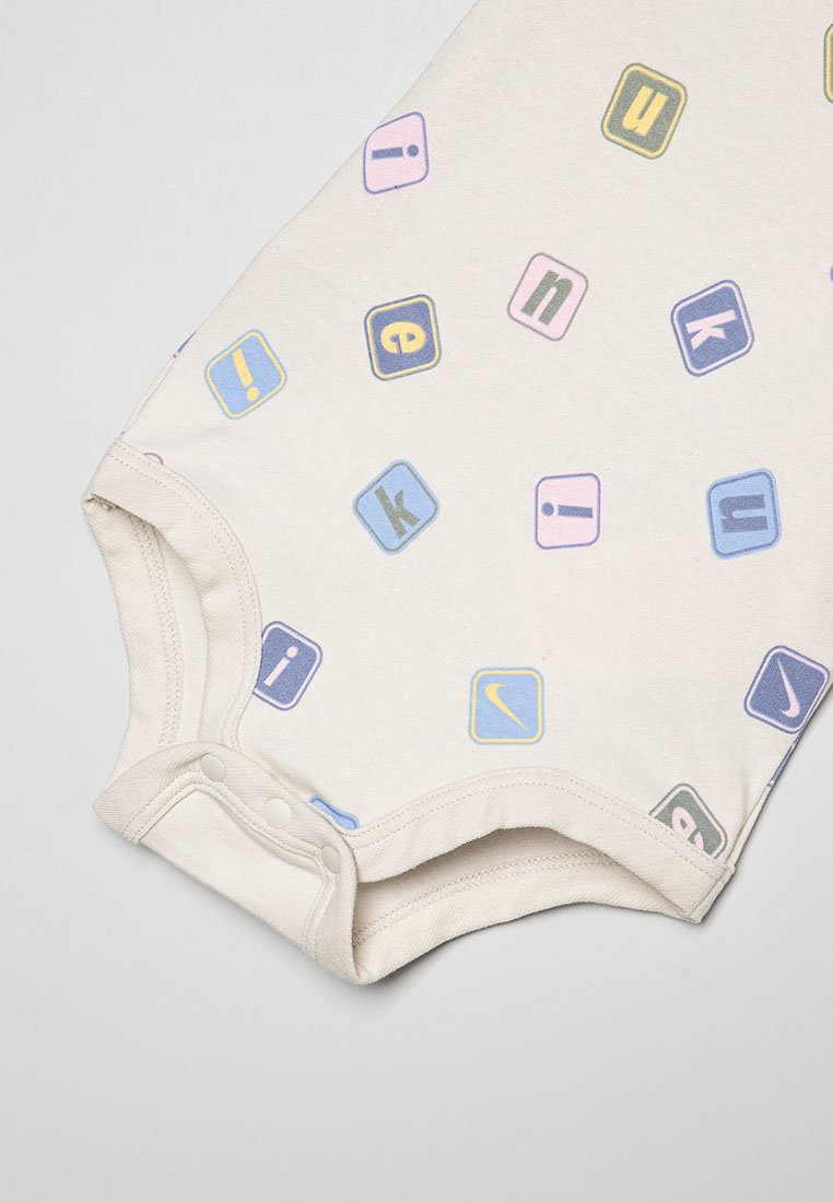 Body en couleur crème pour bébé avec un imprimé graphique en lettres multicolores. Doté de boutons-pression en bas et de manches courtes.