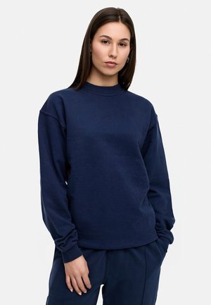 Navy blue sweatshirt with long sleeves, rounded neck, and relaxed fit. Made from soft fabric; ribbed cuffs and hem, minimal design.