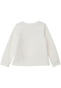 Haut en coton crème à manches longues avec un col rond et des poignets côtelés, présentant une texture lisse et un design simple. Pas de motifs ni d'accents visibles.