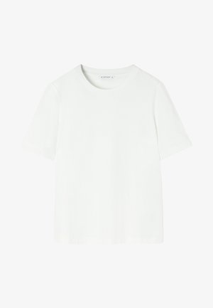 Balta īsām piedurknēm t-krekls, izgatavots no mīksta auduma. Tam ir apaļš kakls un brīvs griezums bez rakstiem vai akcentiem.