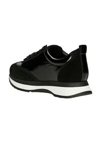 Schwarzer Sportschuh aus einer Kombination von glänzendem Lack- und mattem Wildleder, mit einer weißen Sohle und einem strukturierten Schnürbereich.