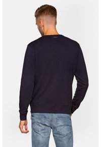 Sweatshirt en coton bleu marine avec manches longues, encolure ronde, poignets et taille côtelés ; texture lisse avec un branding minimal à l'arrière.