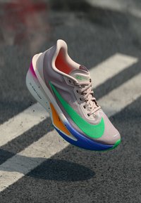 Nike löparskor i ljusrosa med en grön Swoosh, med en texturerad meshövre, flerfärgade sula accenter och synlig dämpning.