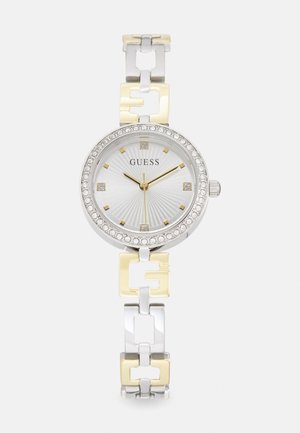 Montre argentée et dorée avec un cadran rond, un cadran texturé blanc, des accents en cristal et un bracelet à maillons avec des touches dorées.
