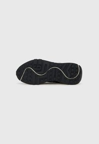 Black rubber shoe sole with a textured surface and patterned grip, featuring a wave design and a light-colored midsole accent.