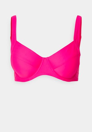 Soutien-gorge rose vif avec armatures, bonnets mous, bretelles ajustables et texture lisse. Conçu dans un style minimaliste.