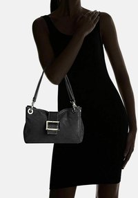 Borsa a mano in pelle nera con design testurizzato, accentuata da una fibbia argento e manici doppi. Forma semplice e compatta, adatta per diverse occasioni.