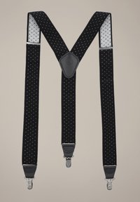 Czarne szelki materiałowe w białe kropki, z akcentami ze skóry i srebrnymi klipsami do mocowania. Projekt w kształcie litery V.