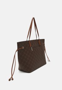 Brązowa torba na ramię z haftowanym wzorem w romby, kontrastującymi jasnobrązowymi uchwytami, sznurkami po bokach oraz małą zasuwaną kieszonką z jednej strony.