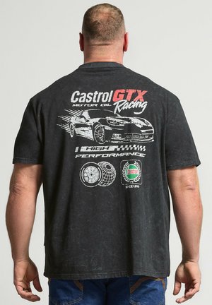 Mann trägt ein schwarzes Castrol GTX Racing T-Shirt mit einem schnell fahrenden Sportwagen, Reifen-Grafiken und Castrol-Logo auf der Rückseite.